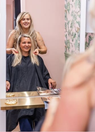 Leanna styling a client's hair in the lounge